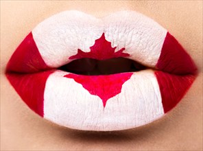 Female lips close up with a picture of the flag of Canada. Red