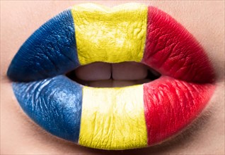 Female lips close up with a picture of the flag of Romania. Blue