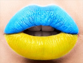 Female lips close up with a picture of the flag of Ukraine. Blue