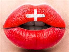 Female lips close up with a picture of the flag of Switzerland. Red and white cross