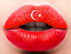 Female lips close up with a picture of the flag of Turkey. Red and white month