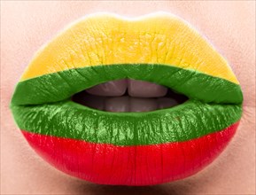 Female lips close up with a picture of the flag of Lithuania. Yellow
