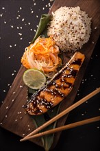 Teriyaki salmon with rice on a wooden platter. Top view. Photo shot in studio