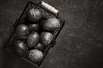 Black painted eggs for Easter in a basket