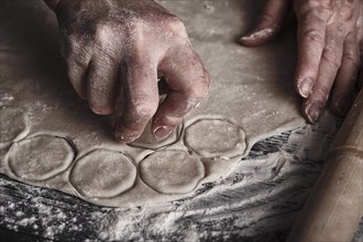 Cooking dough by elderly woman cook hands for homemade pastry dumplings on table background