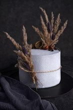Rustic cake on a dark background with dry flowers