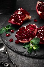 Metal background with pomegranate berries and retro spoons. Vintage style photo