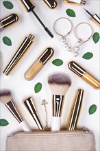 Set of brushes and cosmetic products in a cosmetic bag on a white background