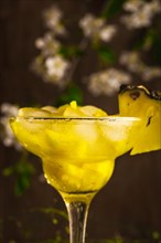 Pineapple fruit soft drink with ice on a wooden background with flowers