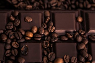 Roasted coffee beans and chocolate bar close-up
