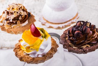 Tasty cakes on a transparent plate on a background of a white tablecloth