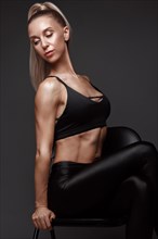 Sports girl with pumped muscles in a tracksuit