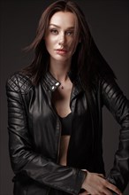 Daring girl model in black leather dress