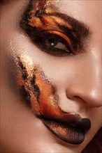 Portrait of a beautiful woman with creative fire art make-up on her face