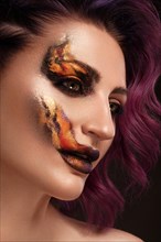Portrait of a beautiful woman with creative fire art make-up on her face