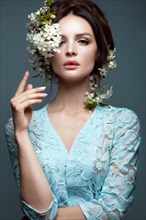 Beautiful brunette girl in blue dress with a gentle romantic make-up