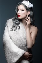 Elegant beautiful girl with silver curls and a veil. Winter image. Beauty face. Picture taken in the studio on a gray background