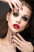 Beautiful girl in leather jacket with bright makeup and manicure Cat's Eye. Beauty face. Nail Design. Picture taken in the studio on a black background