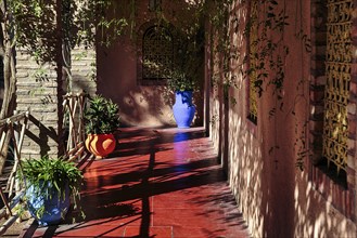 Different coloured flower pots in front of a house in the botanical garden Jardin Majorelle