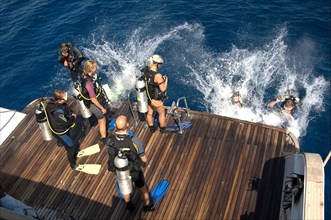 Divers Sport divers jump from dive deck of dive ship for dive cruise into sea water