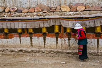Old woman turning the prayer wheels in the kingdom of Guge