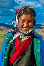 Tibetan woman posing before the mountainous Himalaya landscape along the southern route into Western Tibet