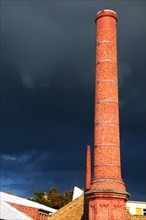 Factory chimney in front of storm clouds