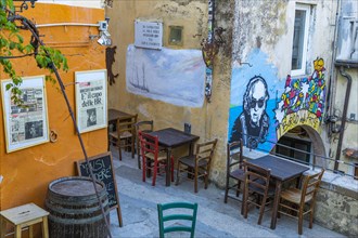 Street cafe with framed historical newspapers and street art in Via Cardenti