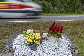 Memorial with cross for victims of road accident on country road