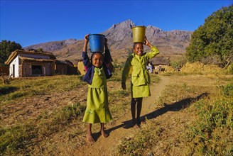 Girls with water buckets on a head