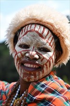 Kikuyu woman with face paint poses for photographers at Nyahururu Falls
