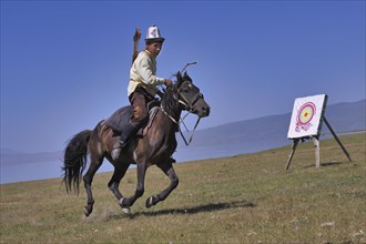 Kyrgyz nomad shooting arrows on a target while galloping