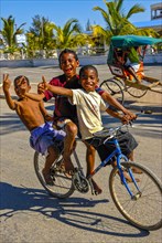 Happy boys cycling through the streets of Toliara