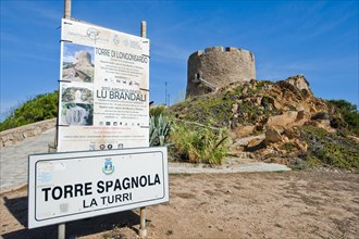 Left tourist information sign Sign for in the background historical Spanish fortified defence tower Torre Spagnola La Turri