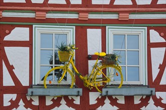 House wall of half-timbered house with flower decoration and bicycle