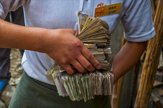 Woman holds bundles of Yuan