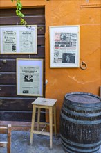 Street cafe with framed historical newspapers in Via Cardenti