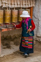 Old woman turning the prayer wheels in the kingdom of Guge