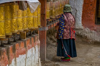 Old woman walking through a temple in the kingdom of Guge