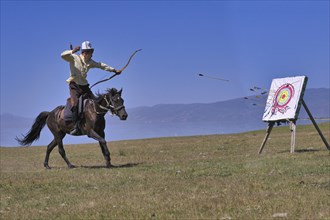 Kyrgyz nomad shooting arrows on a target while galloping