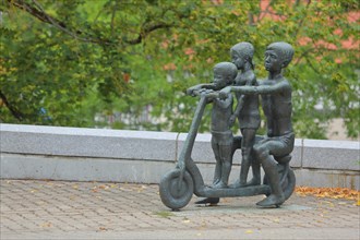 Sculpture with three children on a scooter