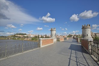Historic stone arch bridge Puente de Palmas built 15th century with two towers and townscape of Badajoz