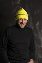 Older man with yellow winter cap laughs