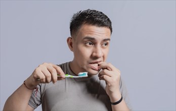 Young man with gingivitis holding toothbrush. People holding toothbrush with gum pain