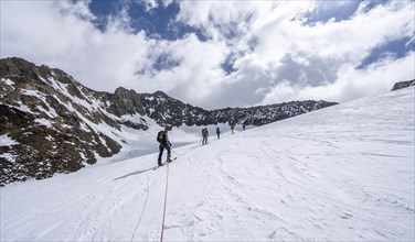 Group of ski tourers ascending on the rope