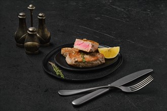 Fried tuna steak on black background