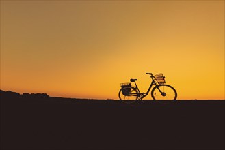 Silhouette of the bike on orange sky