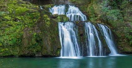 Waterfall from the source of the Lison in a haven of tranquillity with its waterfall surrounded by woods. Banner. Nans-sous-Sainte-Anne