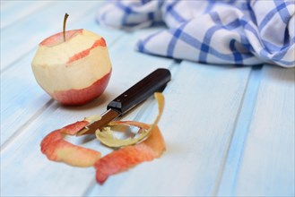 Peeled apple with peeling knife