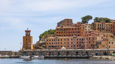 Lighthouse next to houses in pastel-coloured facades